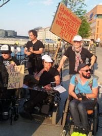 Einige Protestierende mit und ohne Rollstuhl mit Plakat:Echte Teilhabe jetzt