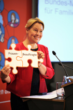 Ministerin Giffey hält lächelnd 2 Puzzleteile hoch: Frauen und Beauftragte