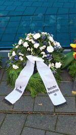 Trauerkranz mit weißen und blauen Blumen und Schleife mit Aufschrift: In Gedenken Deutscher Behindertenrat