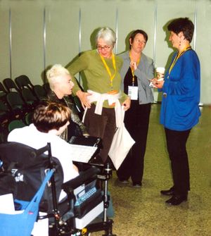 Brigitte Faber talking to 4 women, 2 women using a wheelchair