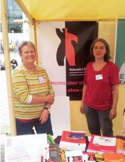 Weibernetz-Vorstandsfrauen Dörte Gregorschewski und Paula Taube hinter dem Stand von Weibernetz